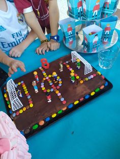 two children are sitting at a table with a cake on it that says happy birthday