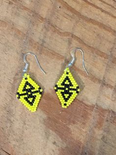 Bright yellow contrasts with vivid black arrowheads in a diamond shaped earring.  Approximately 1 inch in length and 3/4 inches in diameter. Silver plated ear wire. Find us at: www.shelainescreations.store Shelaines Creations @Facebook.com Shelaine2015 @ yahoo.com  www.instagram.com/shelaine2015 www.pinterest.com/shelaine0207 Geometric Yellow Jewelry For Gifts, Handmade Geometric Yellow Jewelry, Dangle Beaded Earrings, Diamond Shape Earrings, Diamond Shaped, Beaded Dangles, Ear Wire, Bright Yellow, Diamond Shapes