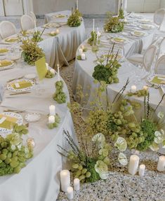 the tables are set up with white linens and green centerpieces on them