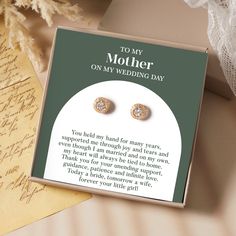 a pair of earrings sitting on top of a card next to an envelope with the message to my mother on my wedding day