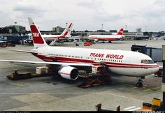 an airplane is parked on the tarmac with other planes in the back ground behind it