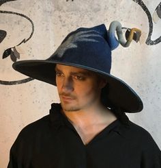 This large brimmed, curly topped Witch or wizard hat is hand felted from blue, yellow and white Merino wool.  The brim is bound in blue dupioni silk and is approximately 18 to 20 inches across. Bear in mind that these are hand felted, so each one will be unique. Your hat will not look exactly like the one pictured but will be equally fabulous.   Fun fact:  This hat starts out around 4 feet wide and 3 feet tall at the beginning of the felting process.  It shrinks around 40% before it is blocked, Witchy Wide Brim Fitted Costume Hat, Fitted Brimmed Hats For Costume Party, Fitted Witchy Hat With Curved Brim, Witchy Fitted Hat With Curved Brim, Fitted Costume Hats And Headpieces With Curved Brim, Fitted Costume Hats With Curved Brim, Flat Brim Halloween Hat, Fitted Brimmed Costume Hats, Fitted Flat Brim Hat For Halloween