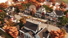 an aerial view of a suburban neighborhood with autumn foliages and trees in the foreground