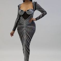 a woman in a black and silver dress posing for the camera with her hands on her hips