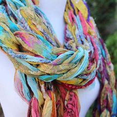 a woman wearing a multicolored scarf on top of a white mannequin