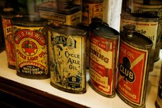 old tins are lined up on a shelf