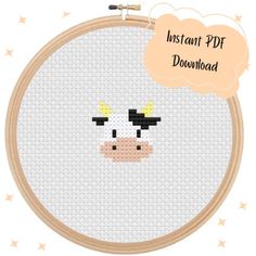 a cross stitch cow with a thought bubble above it