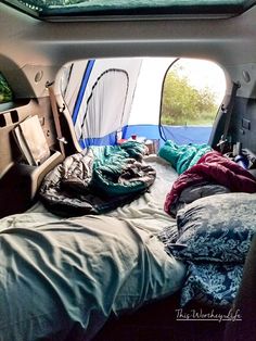 the inside of an rv with several sleeping bags and blankets on the bed in it