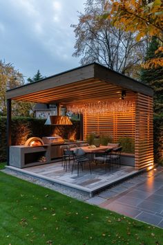 an outdoor kitchen and dining area is lit up at night