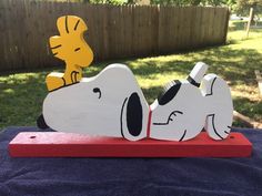 a wooden snoopy dog laying on top of a blue towel