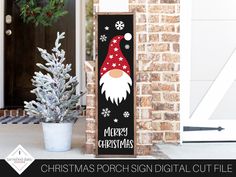 a christmas porch sign sitting next to a potted plant