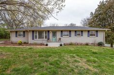 a house with blue shutters and green grass