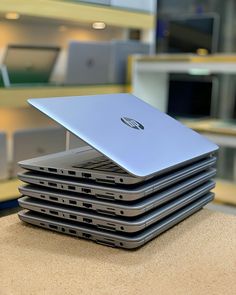 a stack of laptops sitting on top of each other in front of a desk