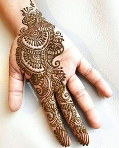 a hand with henna on it that is showing the intricate pattern and design,