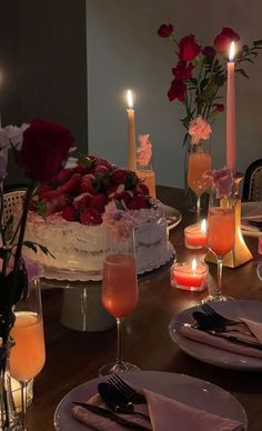 the table is set with candles, plates and cake