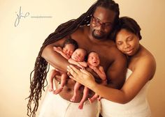 a man and woman holding two babies in their arms