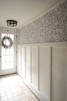 an empty room with a wreath on the door and wallpapered walls behind it