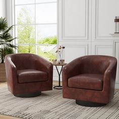 two brown leather chairs sitting on top of a rug