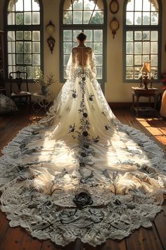 a woman in a wedding dress is standing on the floor with her back to the camera