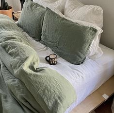 a bed that has some pillows on top of it and a pair of slippers