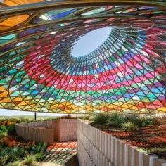 the inside of a building with colorful glass covering it's roof and walkways