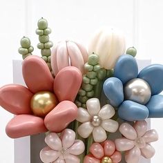 a vase filled with balloons and flowers on top of a table