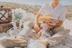 a man sitting on the ground with a baby in his lap