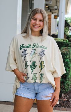 Shopping for new, bold game day tees? We’ve got you covered! The USF “FLASH” Oversized Tee is a must-have! This striking design is perfect for everyday and gameday. The front features the school name, logo, and mascot with a fun mix of patterns to complement your school colors. This tee is super soft and lightweight, keeping you cute and comfy with its trendy, oversized fit. Pair with biker shorts and sneakers for a trendy gameday look! Details: *OFFICIALLY LICENSED* Lightweight Soft Very Oversi Oversized Fan Apparel Tops For Game Day, Oversized Collegiate T-shirt For Game Day, Game Day Logo Print T-shirt For Fall, Casual Tops With University Logo For Game Day, Florida Woman, University Of South Florida, Game Day Outfit, Sarasota Florida, Gameday Outfit