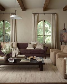 a living room with two couches and a coffee table in front of large windows