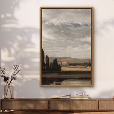 a painting hanging on the wall next to a vase with flowers