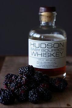 a bottle of hudson baby bourbon and some blackberries