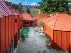 an outdoor courtyard with red roofing and potted plants on either side of the pool