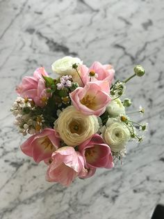 a bouquet of flowers sitting on top of a marble table