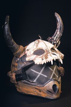 an animal mask with horns on it's head is seen against a black background