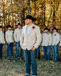 a man standing in front of a group of men wearing cowboy hats and ties,