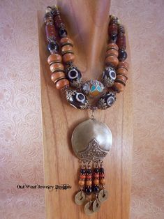 "Check out this gorgeous, chunky Tribal style necklace!! I put it together using some fabulous caramel colored resin beads from Morocco, old brass Chinese coins, large focal black and grey Dzi agate beads, dark caramel colored carnelian drum beads, straw yellow variscite rounds, small brown howlite rondelles, graduated sizes of black agate rounds, dark, tea stained ox bone disks and a fabulous, Nepal resin bead that has handcrafted repousse white brass end caps, repousse white brass decorations Western America, African Beads Necklace, Dark Caramel, Organic Colors, Chunky Jewelry, Bohemian Necklace, African Beads, African Jewelry, Black Agate