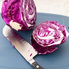 red cabbage cut in half with knife on cutting board