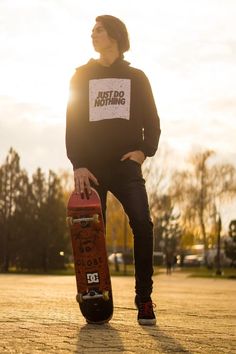 a man standing with his skateboard on the street