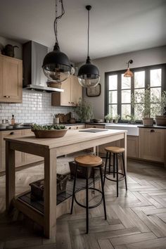 a kitchen with wooden floors and two pendant lights