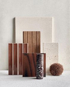 several different types of vases and books on a white surface with a brown pom - pom in the middle