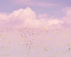 the sky is filled with tiny gold stars in front of a pink and purple background