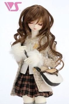 a doll with long brown hair holding a purse