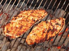 two steaks are cooking on the grill