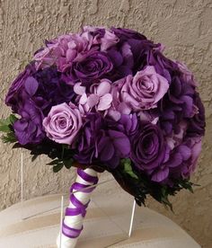 a bouquet of purple flowers sitting on top of a table