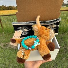 a small stuffed animal is sitting in a box with other items on it's back