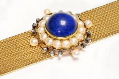 French Lapis Pearl Diamond Bracelet. Experience the timeless elegance of our Antique French 18K Gold Bracelet, featuring a stunning combination of deep blue lapis lazuli, radiant pearls, and rose cut diamonds. Expertly crafted from the finest 18K gold, this piece reflects the exquisite craftsmanship of antique French jewelry. The detailed setting enhances the beauty of each gem, creating a luxurious contrast and making this bracelet a captivating work of art. Perfect for special occasions, it embodies sophistication and timeless charm.This bracelet features authentic French hallmarks, underscoring its exquisite craftsmanship. The mesh design boasts a width of 0.7 inches, while the central piece expands to over an inch in diameter, offering a striking focal point. It is designed to comforta Elegant Lapis Lazuli Gemstone Bracelets, Luxury Cabochon Bracelets For Wedding, Elegant Blue Round Pearl Bracelet, Elegant Blue Pearl Bracelet, Luxury Lapis Lazuli Cabochon Jewelry, Formal Blue Bracelets With Cabochon, Luxury Wedding Bracelet With Cabochon, Elegant Lapis Lazuli Bracelets For Gifts, Elegant Cabochon Bangle Jewelry