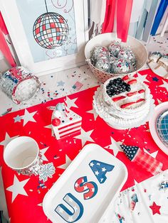 a table topped with plates and cake next to a flag wallpapered wall in the background