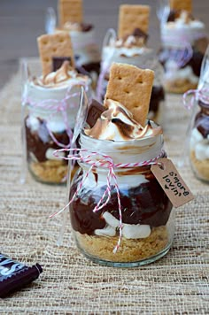 desserts in glass jars with crackers and marshmallows on the table