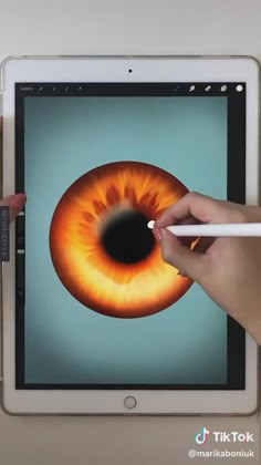 a person is drawing an eyeball on the screen of a tablet with a pencil