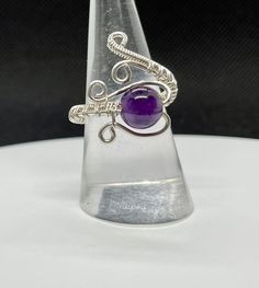 Adjustable Size Sterling Silver wire wrapped Ring with Amethyst. Adjustable from size 7-11. Amethyst is one of the most famous and prominent crystals because of its beautiful coloration as well as its spiritual and literal meaning. The spiritual meaning of Amethyst is groundedness, tranquility, and calm. Wire Wrapped Ring, Wire Jewelry Designs, Band Fits, Sterling Silver Wire Wrap, Spiritual Meaning, Wire Wrapped Rings, Ring Sizes, Wrap Rings, Amethyst Gemstone